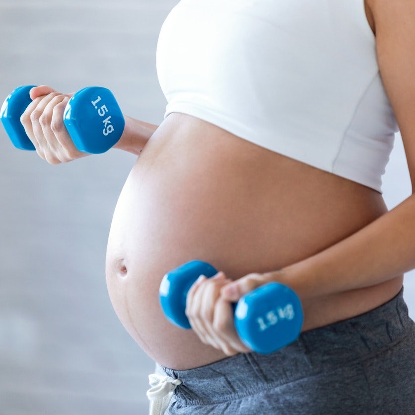 Close up of pregnant woman with weights SQUARE