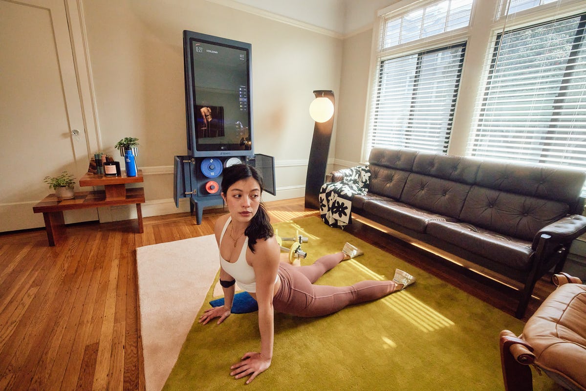 Woman Stretches in living room with Tempo Studio